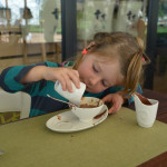 A little girl is eating food at the table