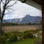 A view of mountains from the porch of a house.