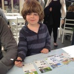 A young boy sitting at a table with cards.