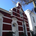 A red and white building with a clock on the front.