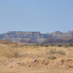 A desert landscape with mountains in the background.