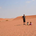 A man and two children in the desert.